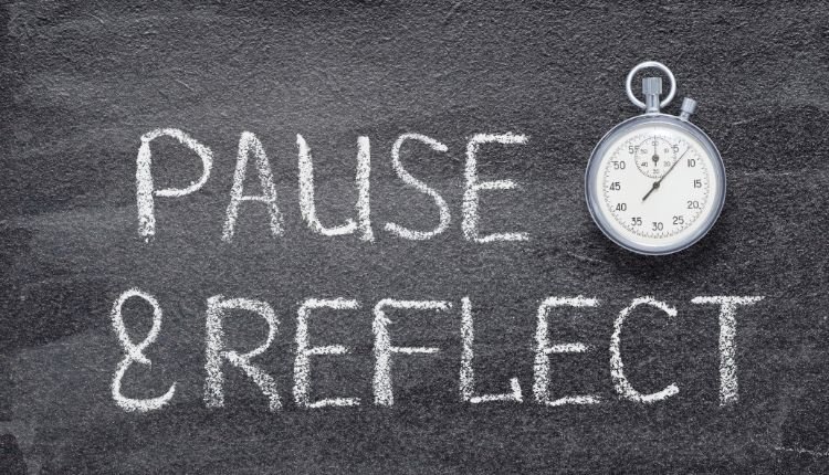 Chalkboard with "Pause & Reflect" written in chalk and a stopwatch.