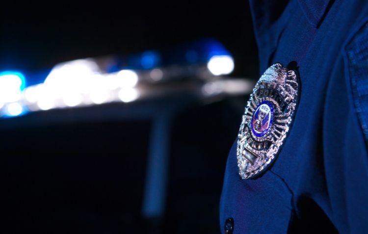 How Long Is Police Academy? Close-up of police badge at night.