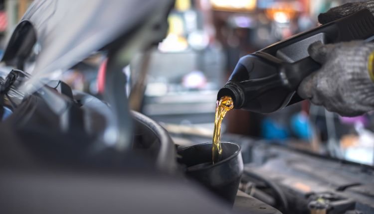 Mechanic pouring engine oil during service