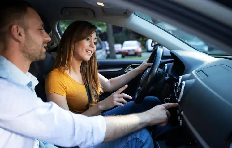 Driving instructor guiding a student—how much are driving lessons?