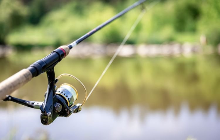 Fishing reel and rod by the water, ready for casting