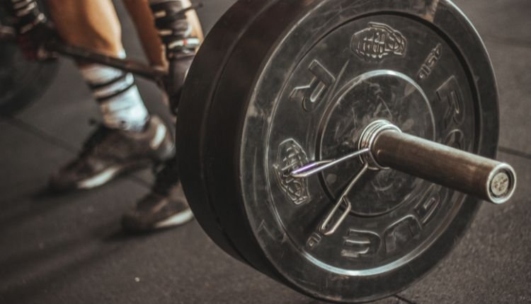 Close-up of a weight plate on a barbell at the gym.