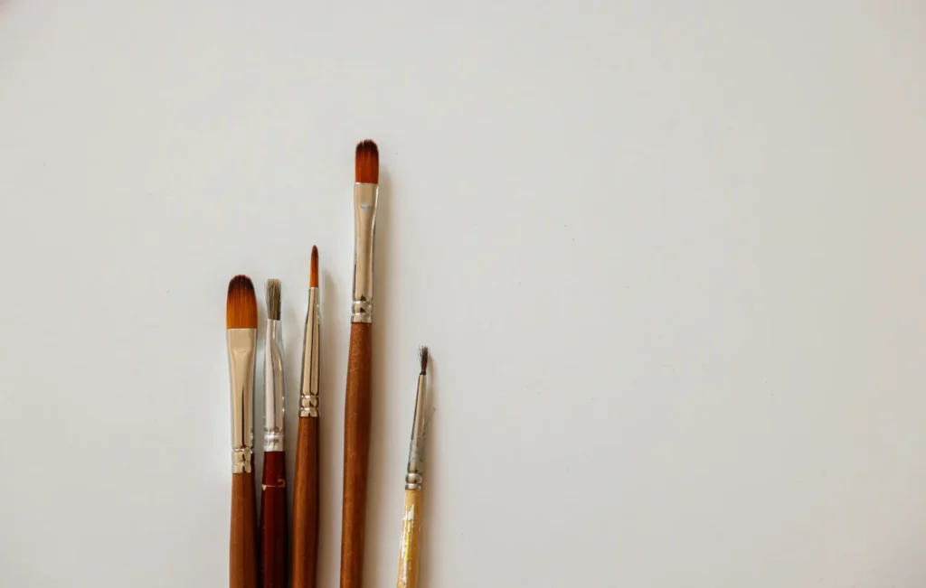 Clean paint brushes arranged neatly on a white background.