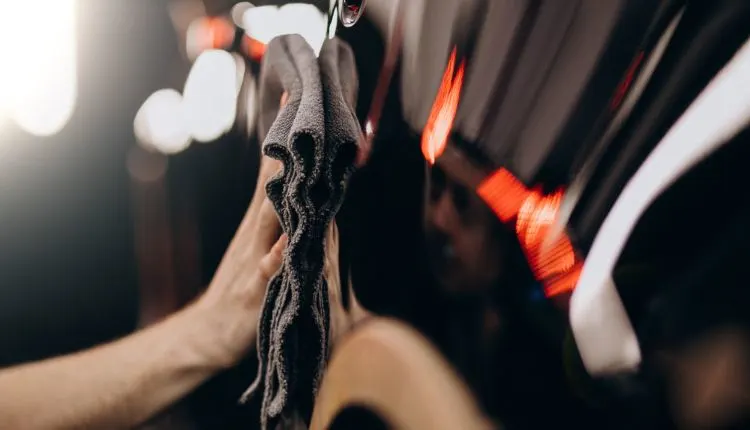 How Much Is Ceramic Coating? Find Out Now 2 Hand buffing a shiny car with microfiber cloth