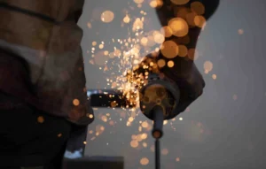 How Much Is Welding School? Student grinding metal