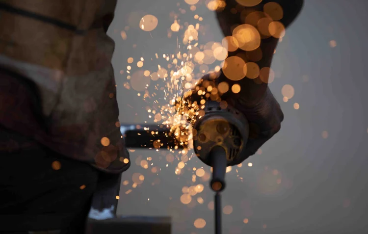 How Much Is Welding School? Student grinding metal